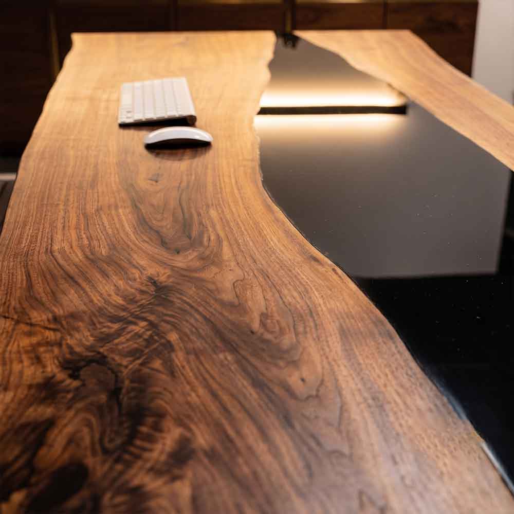 Black Walnut Wood desk with keyboard and mouse on a blurred background