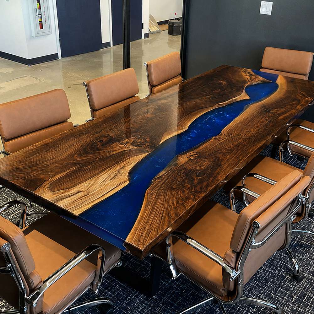 Black walnut conference table featuring a sapphire blue epoxy river in a modern executive boardroom
