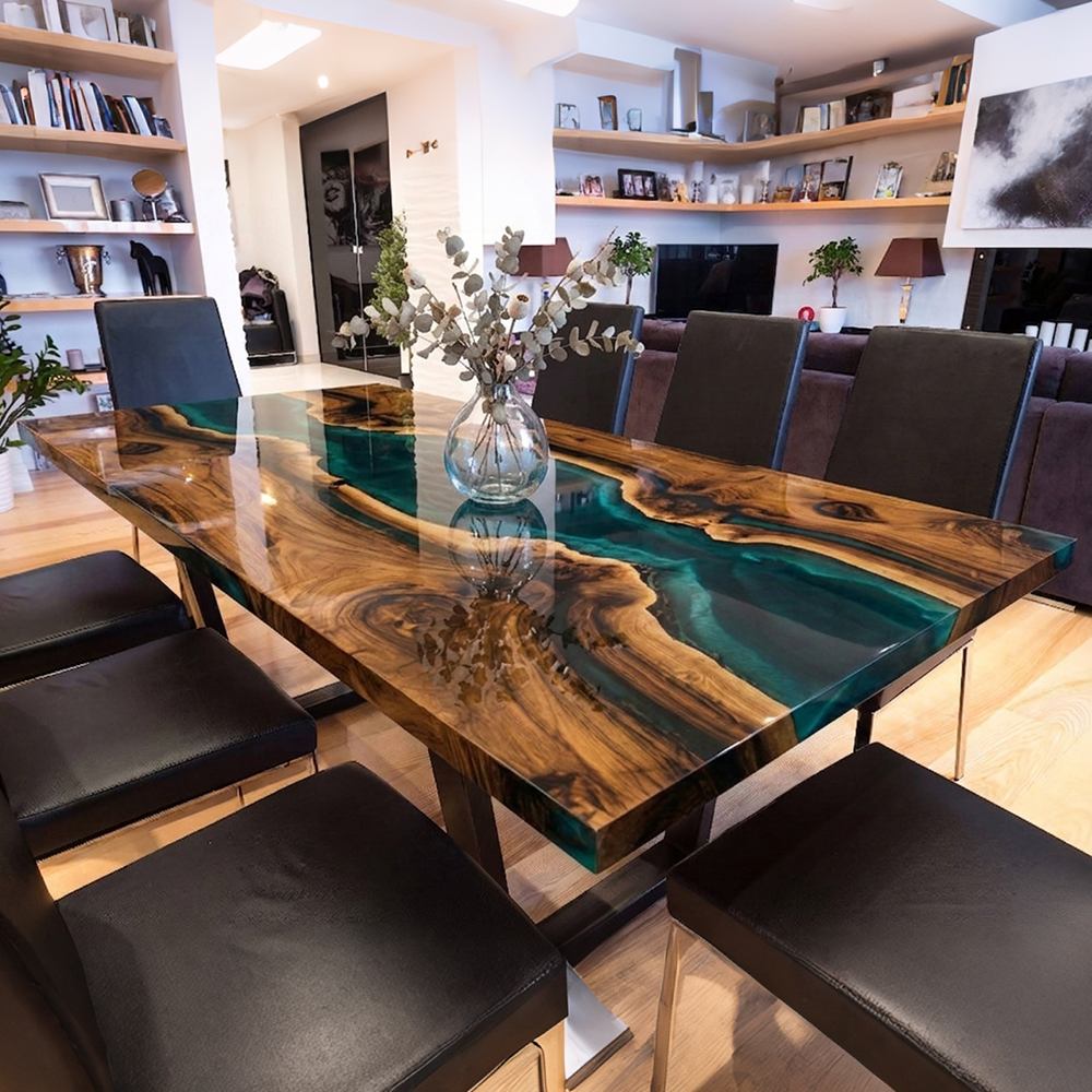 Dining room shot of extra long live edge walnut dinner table with crystal clear teal blue transparent epoxy river surrounded by light fabric dining chairs