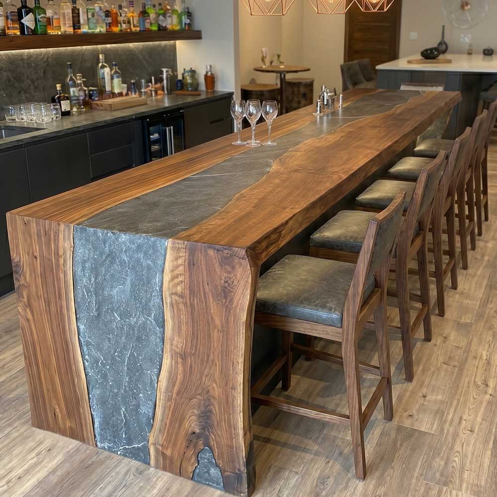 Long wooden bar counter with stools in a modern kitchen setting