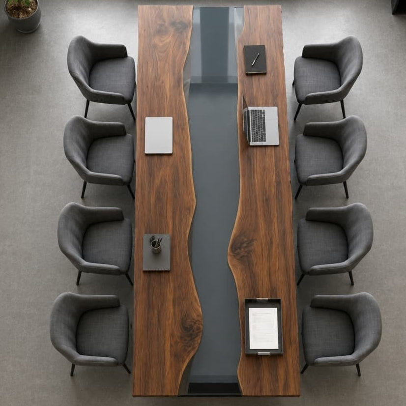 Clean overhead view of a silver laptop and office stationery on a sleek handcrafted black walnut and clear gray resin desk