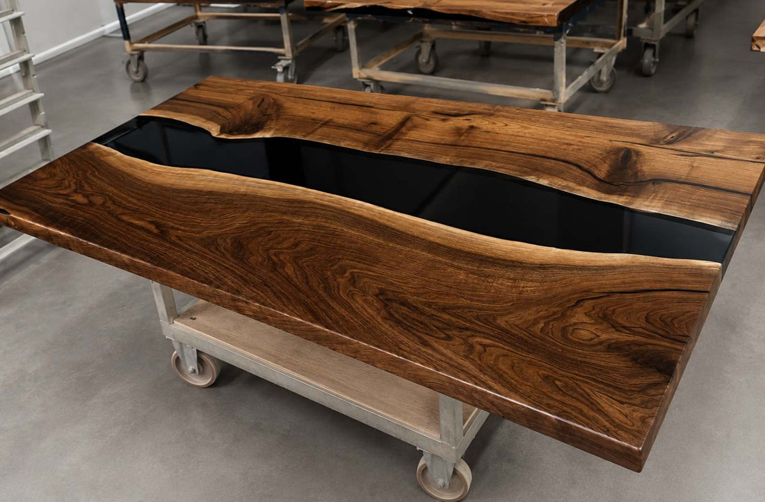 Finished black walnut epoxy river table with black resin, showing a polished custom wood slab table in the workshop before delivery
