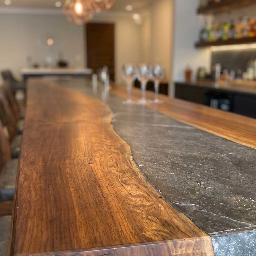 Long wooden bar with a stone finish in a blurred bar or restaurant setting