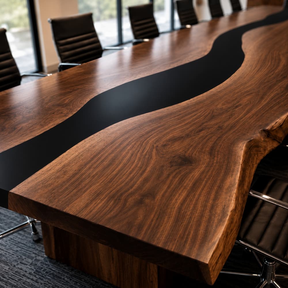 Live edge boardroom table featuring natural walnut grain and a black resin river