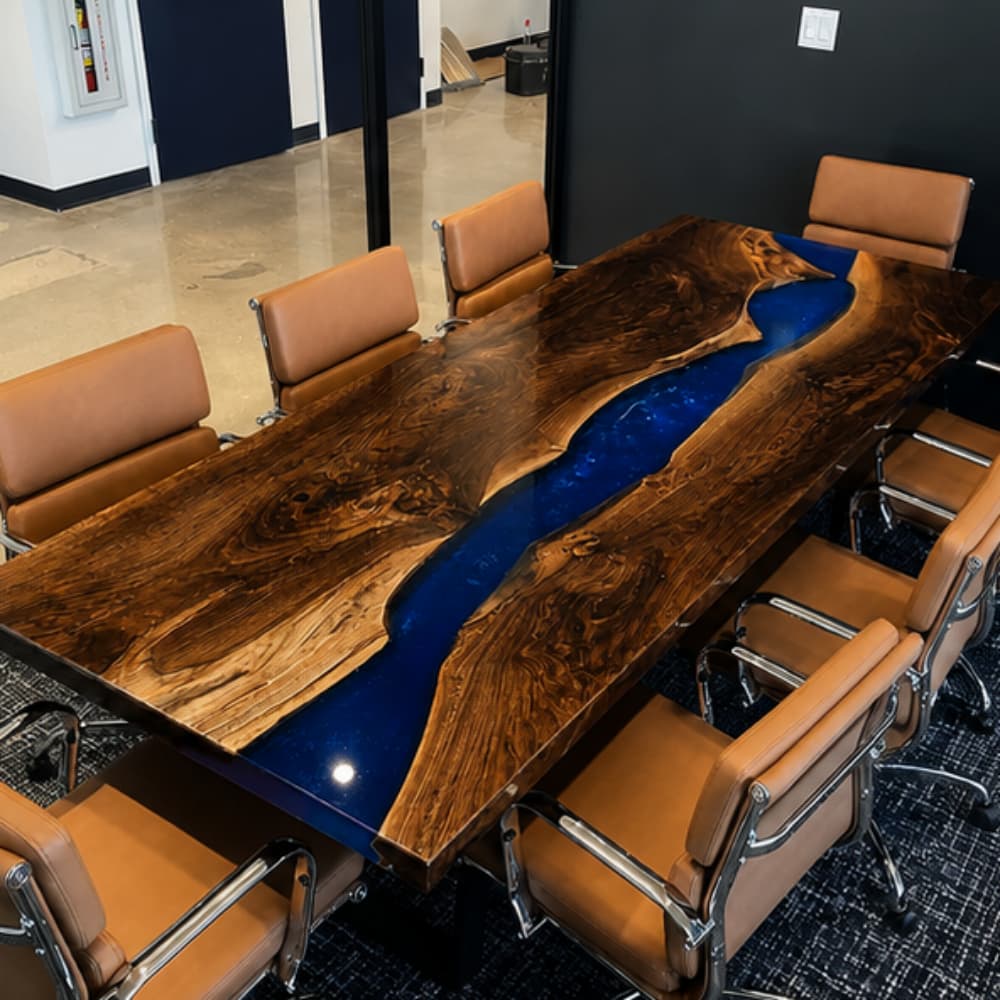 A luxurious conference table featuring premium burl walnut slabs and a deep cobalt blue resin river, set in a professional high-end office environment