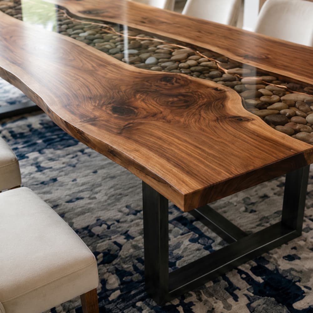High-end dining room styling featuring a large wooden river table paired with elegant white velvet dining chairs