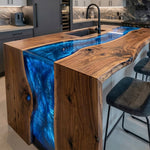 High-end modern open kitchen featuring a handcrafted organic wood and blue river breakfast bar.