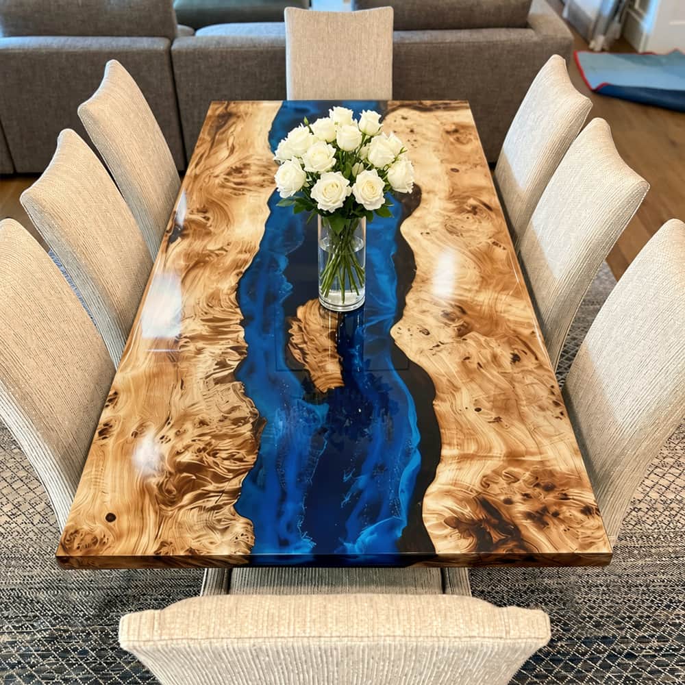 Luxury maple dining table combining natural wood grain and deep blue epoxy resin.