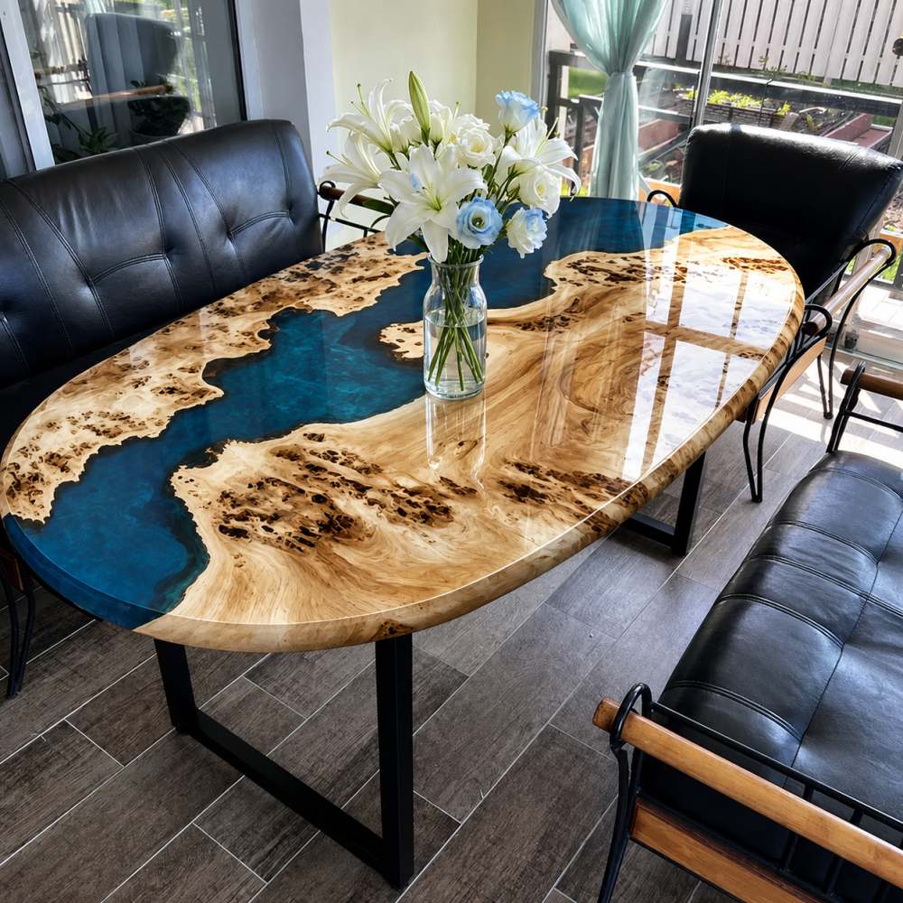 Close-up shot of rare figured burl maple burly grain and translucent deep blue ocean epoxy river on oval boat-style coffee tabletop