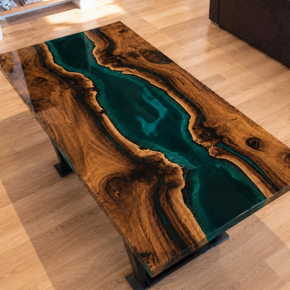 Texture-focused close-up capturing the raw natural wavy live edge junction between rich walnut timber and saturated translucent deep teal epoxy resin on custom solid wood dining table