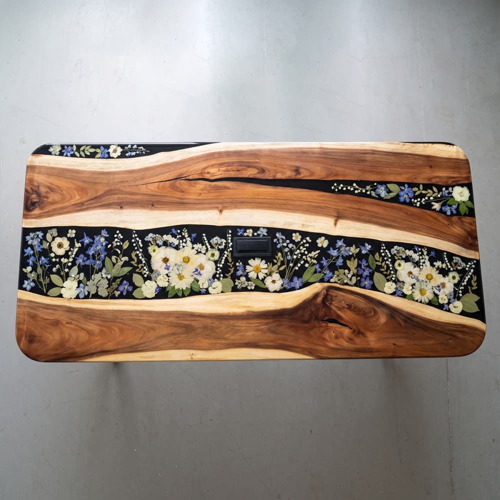 Rich natural walnut wood grain seamlessly merging with a botanical resin river on an artisanal dining room centerpiece.