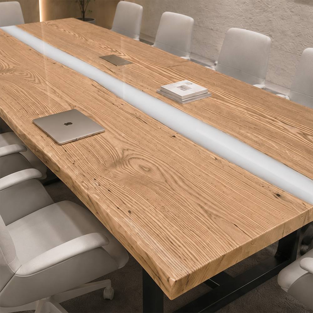 Opaque white epoxy river running between natural ash wood slabs on a custom executive meeting table
