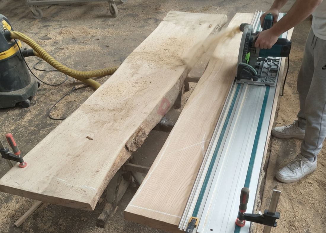 Craftsman planing and shaping raw wood slabs for a custom epoxy river table