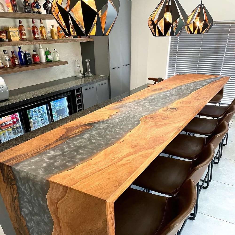 Styled vignette of walnut silver swirl epoxy bar countertop decorated with coffee mug, open book and fresh flower glass vase